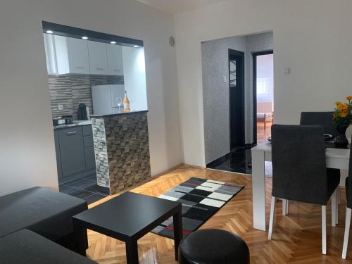Svetao enterijer dnevnog boravka u objektu Apartman Lana u Aranđelovcu sa modernim nameštajem, kuhinjom i balkonom u centru grada.